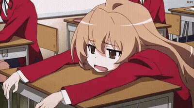 A Girl Is Sitting At A Desk In A Classroom With Her Head On The Desk . GIF