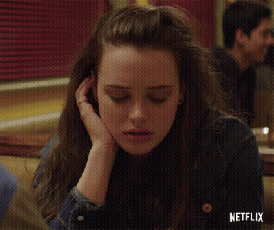 A Girl Is Sitting At A Table With Her Hand On Her Face And A Netflix Logo In The Corner GIF