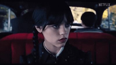 A Girl Is Sitting In The Back Seat Of A Car With A Netflix Logo On The Screen GIF
