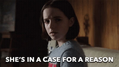 A Girl Is Sitting On A Couch With The Words She 'S In A Case For A Reason Above Her GIF