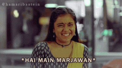 A Girl Is Smiling With The Words Hai Main Marjawan Above Her GIF