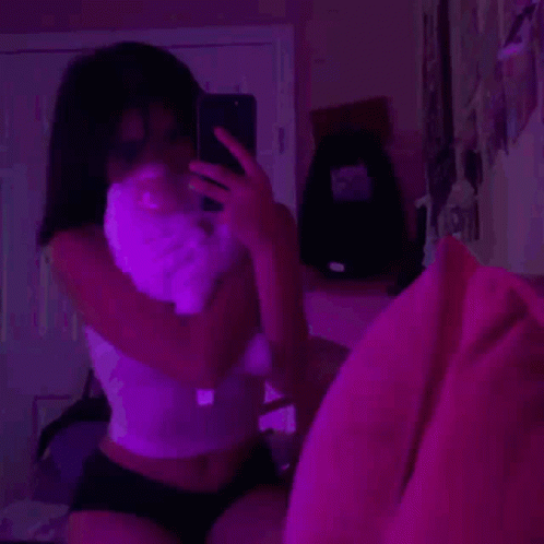 A Girl Is Taking A Selfie With A Cat In Her Hand . GIF