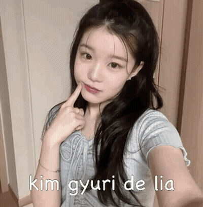 A Girl Is Taking A Selfie With Her Finger In Her Mouth And The Words Kim Gyuri De Lia Written On The Bottom . GIF