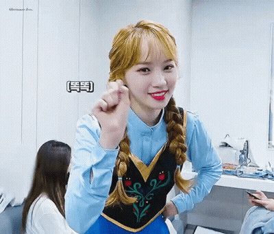 A Girl Is Wearing A Frozen Costume And Making A Heart Shape With Her Hand . GIF