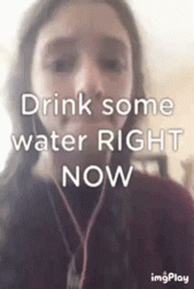 A Girl Is Wearing Headphones And Says Drink Some Water Right Now . GIF