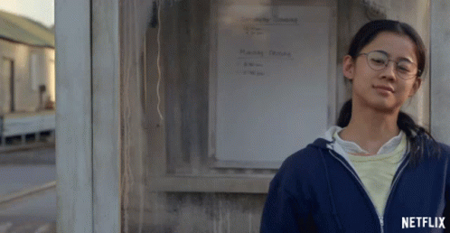 A Girl Leaning Against A Wall With A Netflix Logo On The Bottom Right GIF