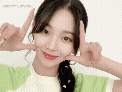 A Girl Making A Peace Sign In Front Of A White Background With The Word Next Level GIF