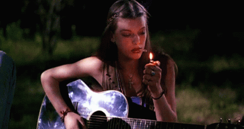 A Girl Playing A Guitar And Lighting A Cigarette GIF