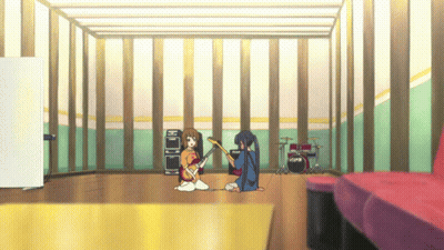 A Girl Playing A Guitar In A Room With A Drum Set GIF