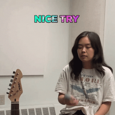 A Girl Playing A Guitar With A Nice Try Sticker Above Her GIF