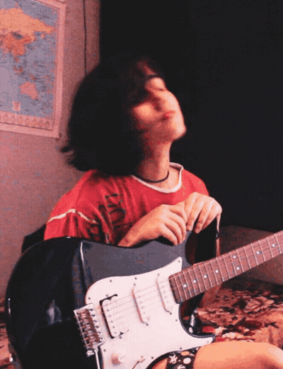 A Girl Playing An Electric Guitar In Front Of A Map GIF