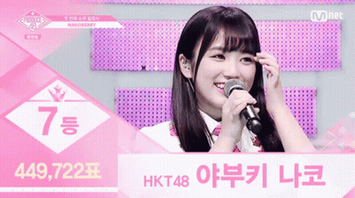 A Girl Singing Into A Microphone With The Number 7 On The Top GIF