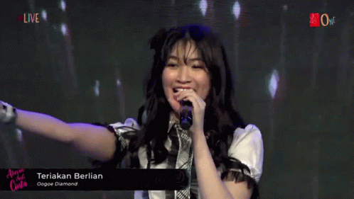 A Girl Singing Into A Microphone With The Words Teriak Berlian On The Bottom Right GIF
