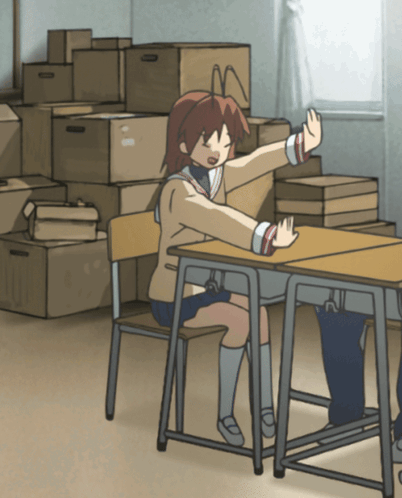 A Girl Sits At A Desk In Front Of A Stack Of Cardboard Boxes GIF