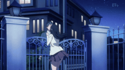 A Girl Stands In Front Of A Building With A Fence And A Sign That Says Nhk E GIF