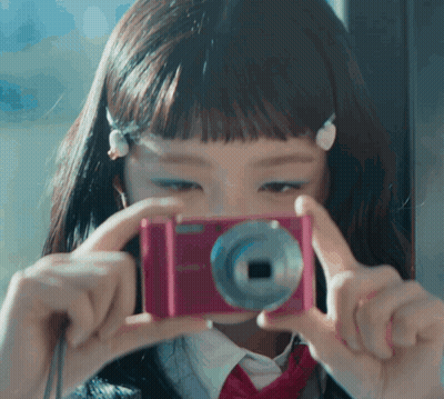 A Girl Takes A Picture With A Pink Camera GIF