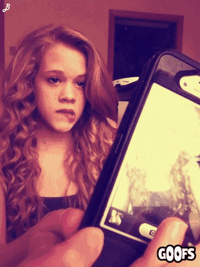 A Girl Taking A Picture Of Herself With A Phone That Says Goofs On The Bottom GIF