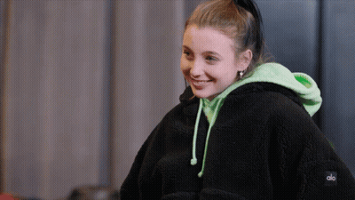 A Girl Wearing A Black Hoodie With The Word Alo On The Back GIF