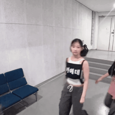 A Girl Wearing A Black Tank Top That Says ' Ae ' On It GIF