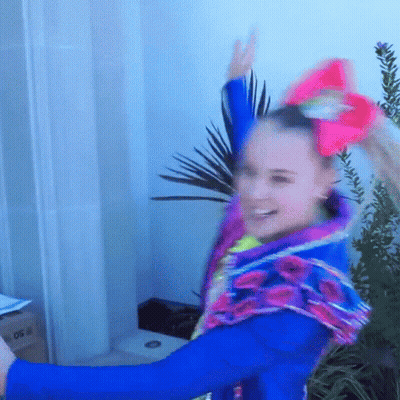 A Girl Wearing A Blue Jacket And A Pink Bow On Her Hair GIF