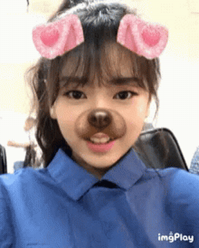 A Girl Wearing A Blue Shirt Has A Fake Dog Nose On Her Face .. GIF