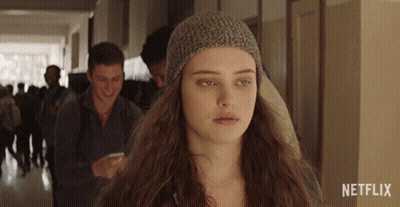 A Girl Wearing A Knitted Hat Is Standing In A Hallway With Netflix Written On The Bottom GIF