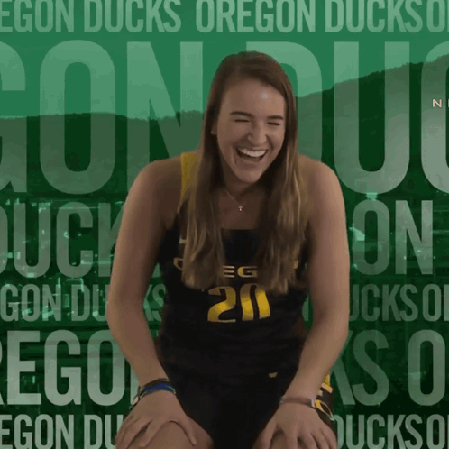 A Girl Wearing A Number 20 Jersey Is Laughing GIF