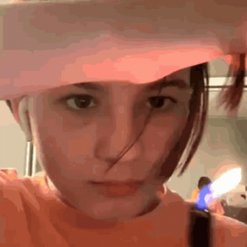 A Girl Wearing A Pink Hat And An Orange Shirt GIF