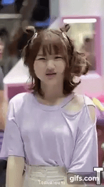 A Girl Wearing A Purple Shirt Is Making A Face . GIF