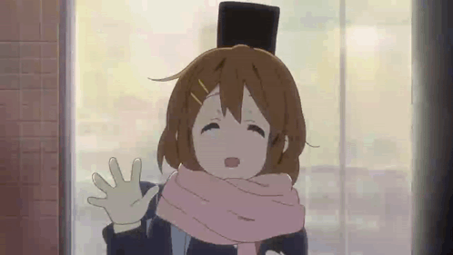 A Girl Wearing A Scarf And A Top Hat Is Waving At The Camera . GIF