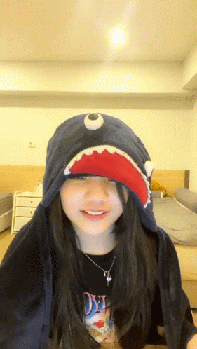 A Girl Wearing A Shark Hat And A Shirt That Says Dyi On It GIF
