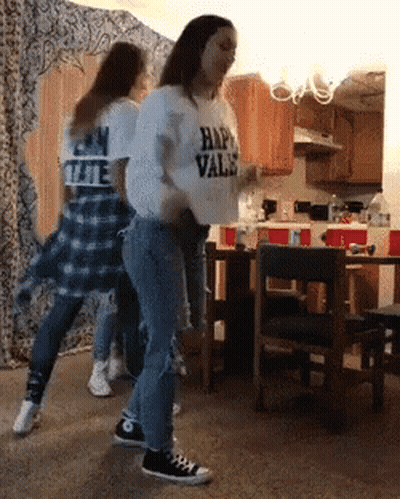 A Girl Wearing A Shirt That Says Happy Vals Is Dancing In A Kitchen GIF