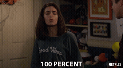 A Girl Wearing A Sweater That Says Good Vibes Blows A Kiss GIF