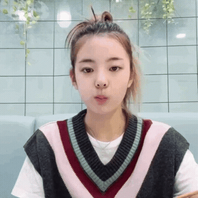A Girl Wearing A Sweater Vest And A White Shirt GIF