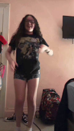 A Girl Wearing A T-Shirt That Says ' Avengers ' On It Is Dancing GIF