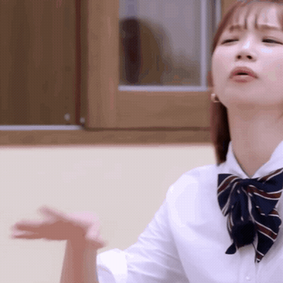 A Girl Wearing A White Shirt And A Bow Tie Is Making A Funny Face . GIF