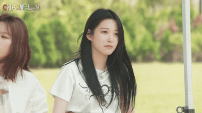 A Girl Wearing A White Shirt With Chanel 9 Written On It GIF