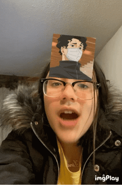 A Girl Wearing Glasses And A Fur Coat Has A Picture Of A Man On Her Face GIF