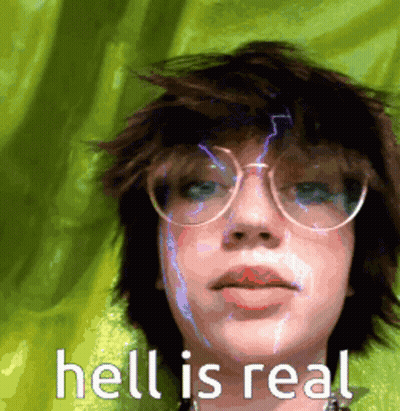 a girl wearing glasses and a green shirt with the words hell is real on the bottom