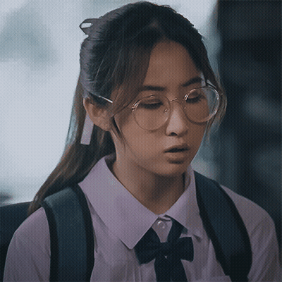 A Girl Wearing Glasses And A White Shirt With A Black Bow GIF