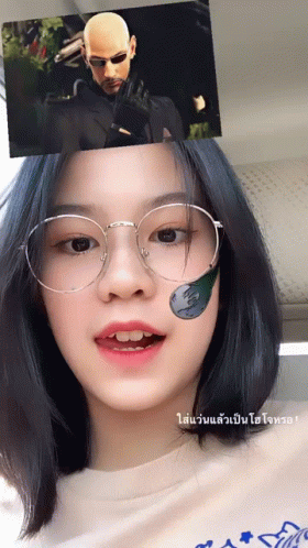 A Girl Wearing Glasses Has A Sticker On Her Face That Says ' Matrix ' GIF
