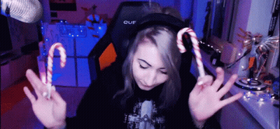 A Girl Wearing Headphones Holds Up Two Candy Canes In Front Of A Microphone GIF