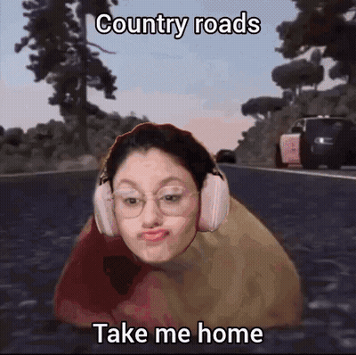 A Girl Wearing Headphones Is Laying On A Road With The Caption Country Roads Take Me Home . GIF