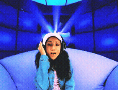 A Girl Wearing Headphones Is Sitting In A Chair GIF