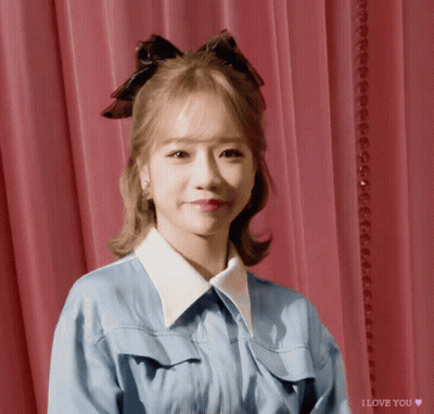 A Girl With A Bow In Her Hair Says I Love You On The Bottom GIF