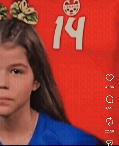 A Girl With A Bow In Her Hair Stands In Front Of A Red Background With The Number 14 GIF