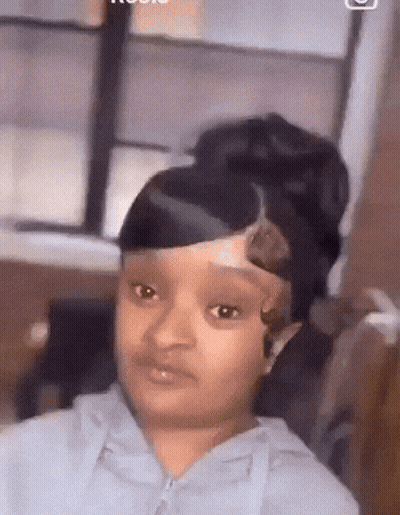 A Girl With A Bun On Her Head Is Looking At The Camera . GIF