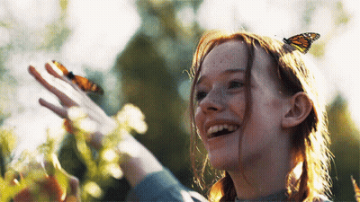A Girl With A Butterfly On Her Head Looks Up At The Sky GIF