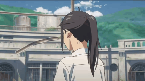 A Girl With A Ponytail Stands In Front Of A Large Building GIF