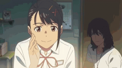 A Girl With An X In Her Hair Is Smiling And Looking At The Camera GIF